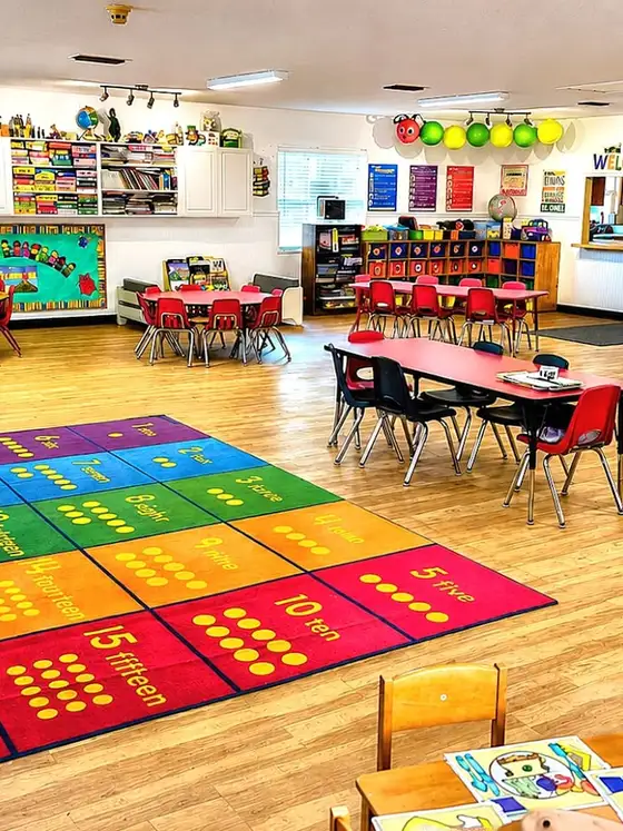 A classroom with a large colourful numbers rug